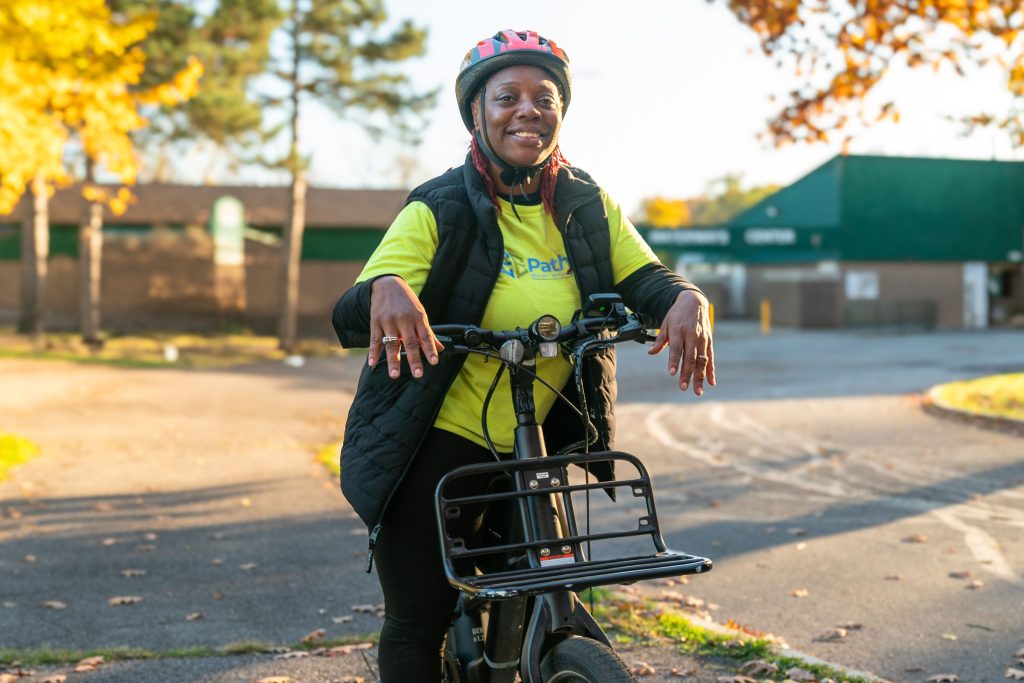 a woman wearing a helmet and holding a bike