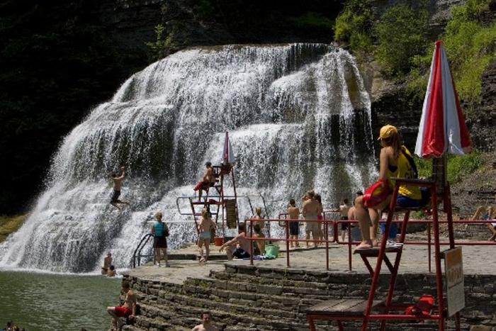 a group of people swimming in a waterfall