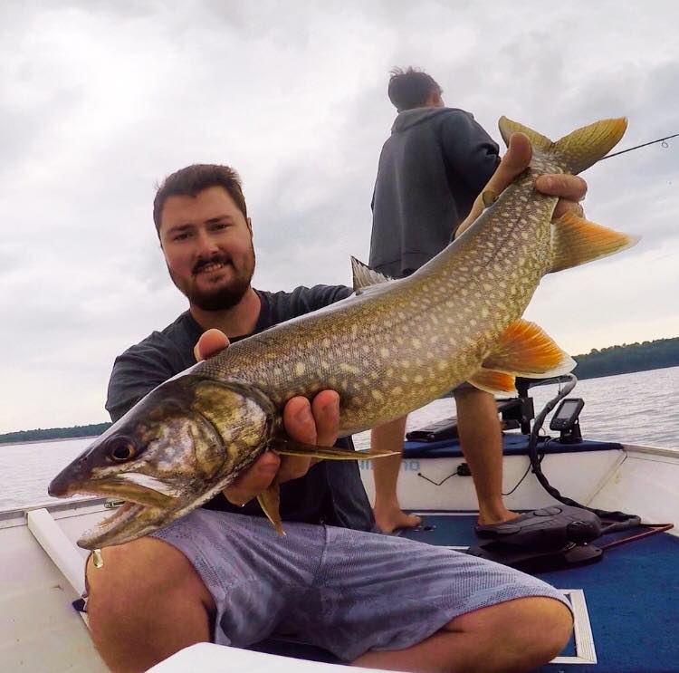 Find Hidden Gems of the Finger Lakes Region - Fishing for Adventure a man holding a fish in a boat